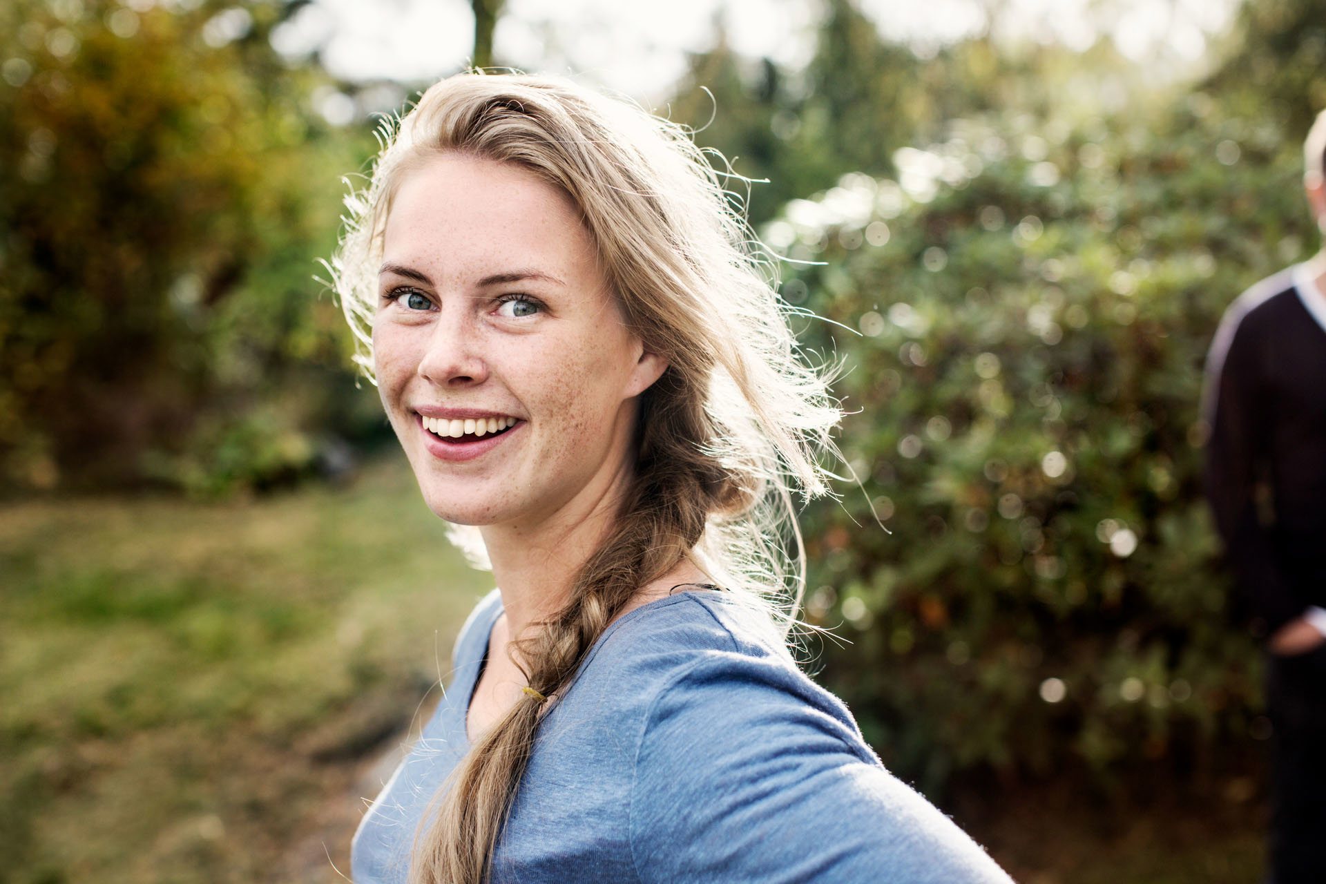 Vrouw in de tuin kijkt lachend in de camera l Vattenfall energie