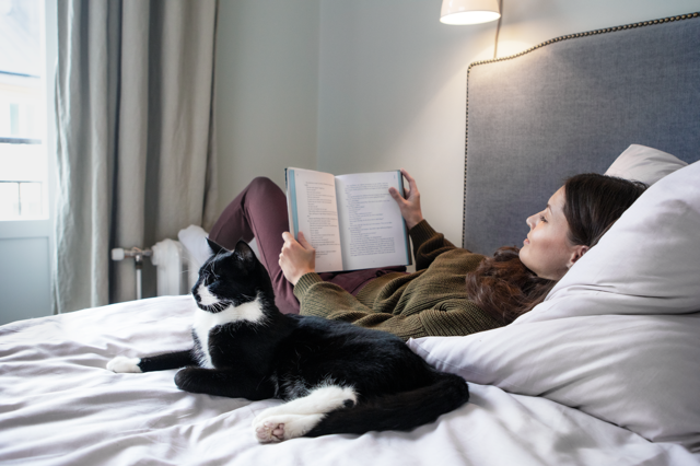 Vrouw op bed leest een boek