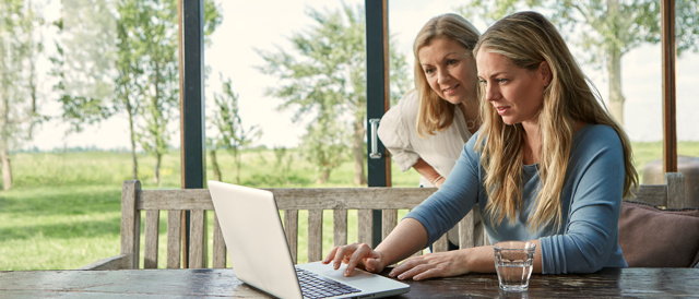 Twee dames aan tafel werkend op laptop l Vattenfall energie