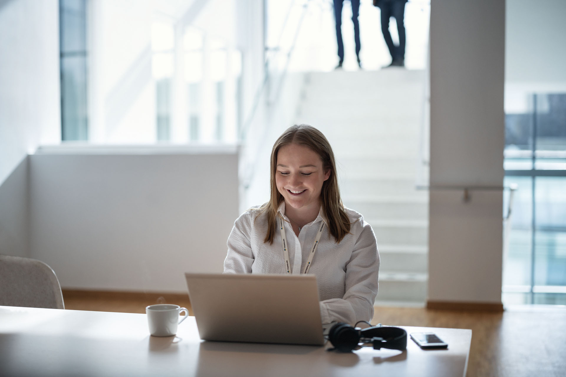 Vrolijke collega in vergaderruimte met laptop checkt Mijn Vattenfall