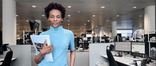 Zakenvrouw in lichtblauw shirt in kantoortuin - energie nieuws voor ondernemers