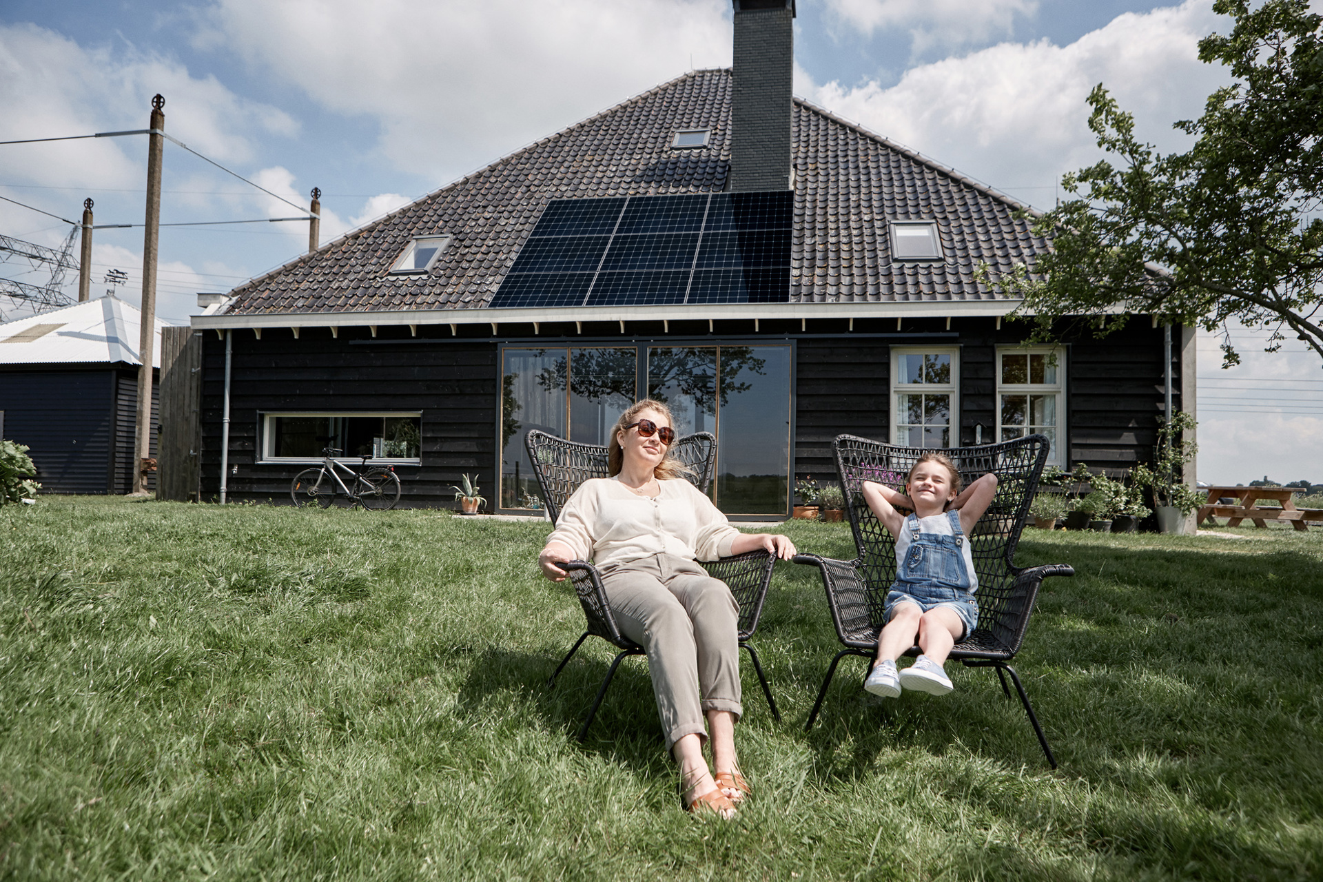 moeder en kind zonnen met zonnepanelen op achtergrond | Vattenfall zonnepanelen