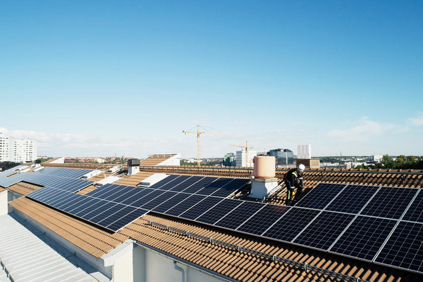 Veel zonnepanelen op een serie daken in de stad