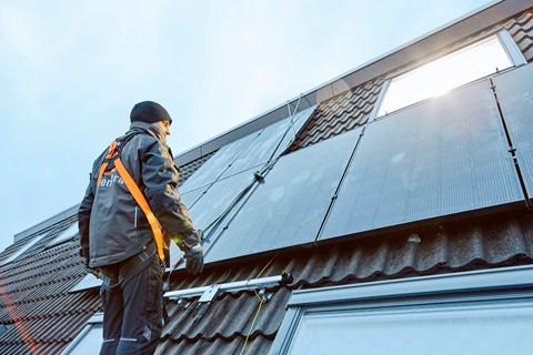 Installateur op het dak met zonnepanelen