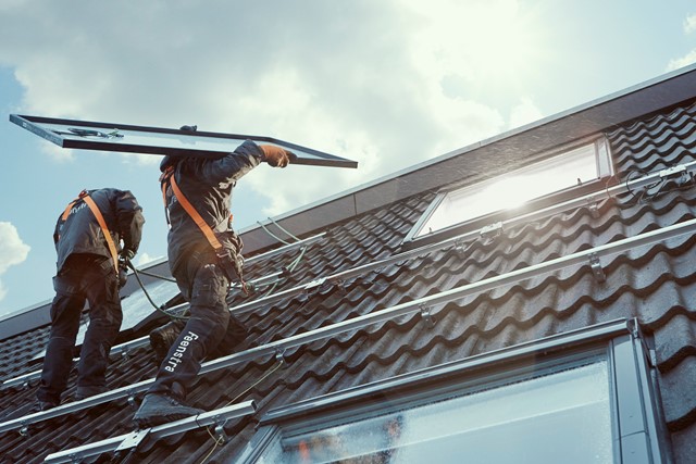 Installateurs met zonnepanelen op dak