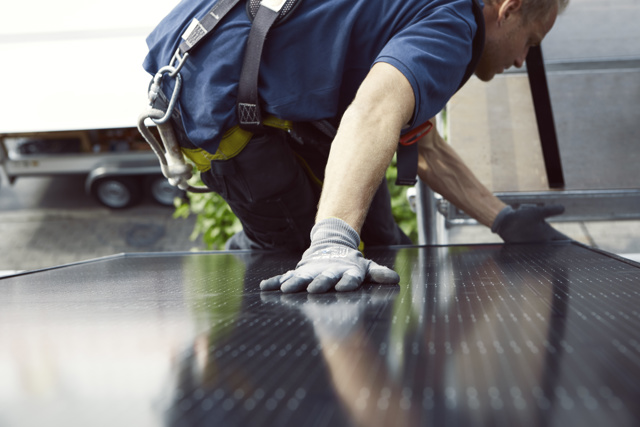 Zonnepanelen monteur met hand op zonnepaneel - hoe werken zonnepanelen