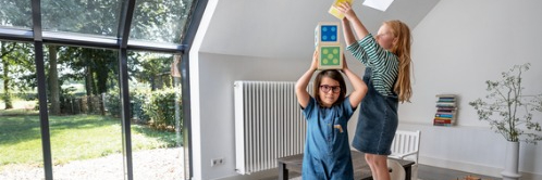 Twee meisjes spelen met grote blokken in lichte kamer