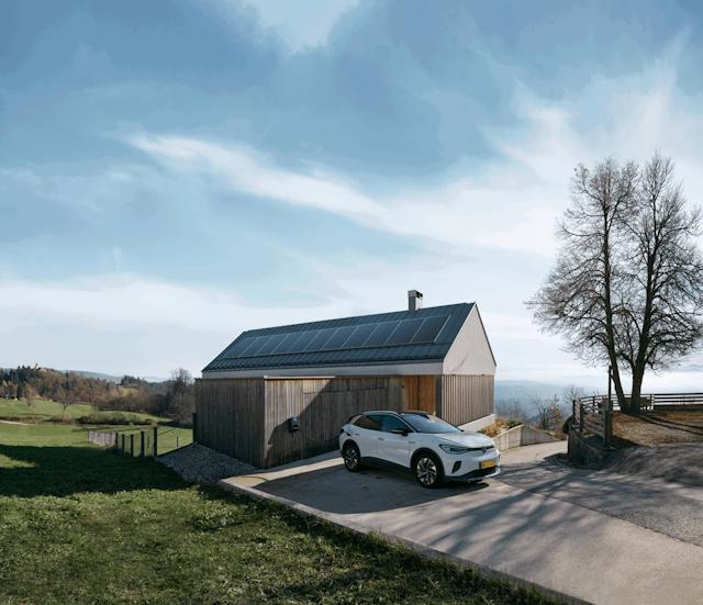 Woning met zonnepanelen en een elektrische auto aan een laadpunt