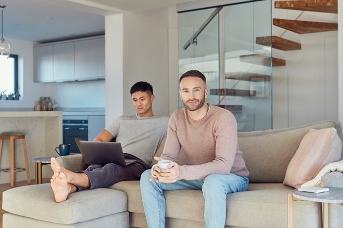 Mannen zitten op de bank in hun woonkamer