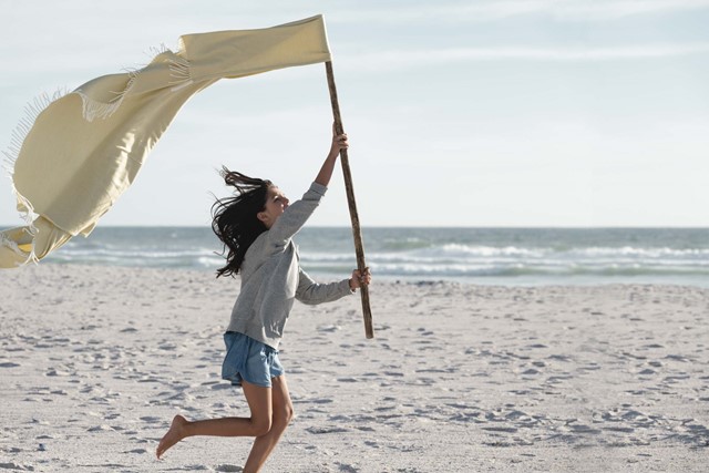 Meisje rent blij over strand met vlag | Vattenfall