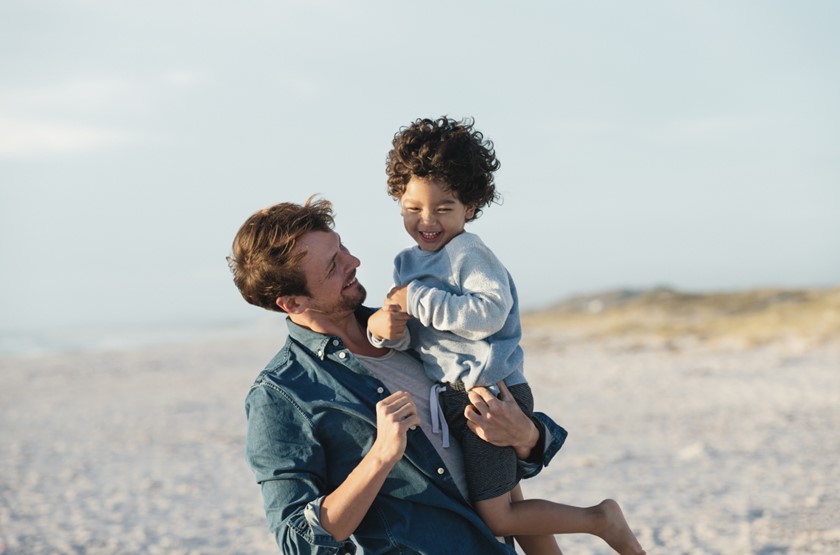 Vader met zijn zoontje op de arm op het strand | Vattenfall over gas, water, licht kosten