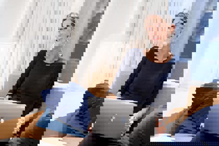 Elk naar voordeel voor klanten die bij Vattenfall blijven | Jonge vrouw met laptop op schoot op de bank