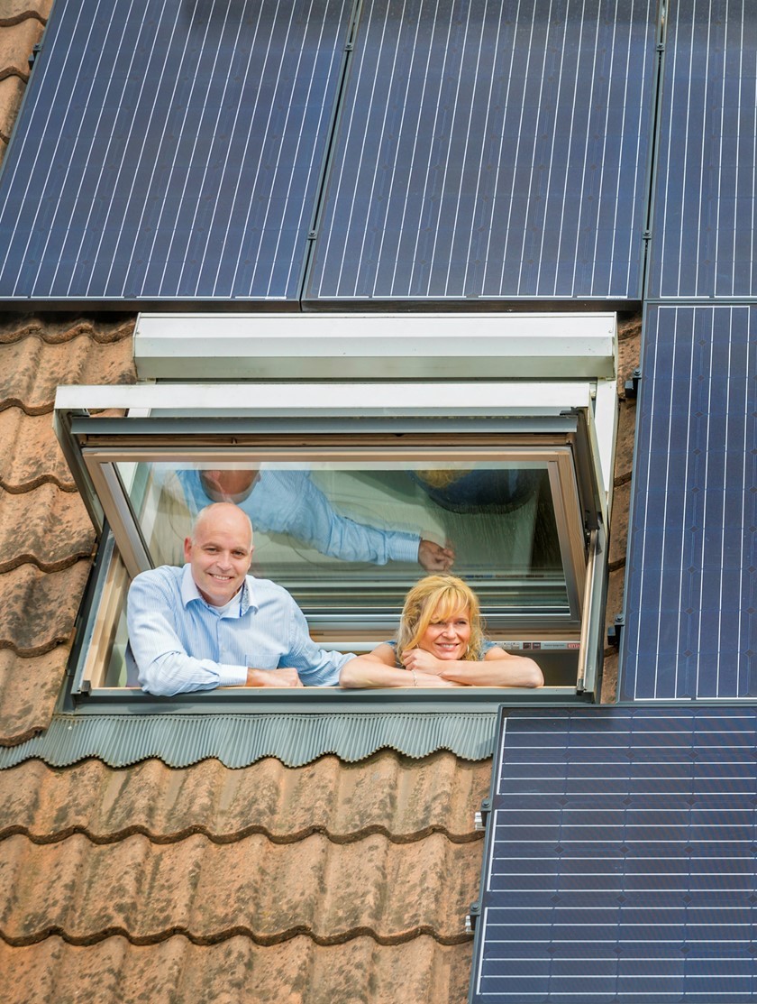 Echtpaar kijkt uit hun dakraam waarop zonnepanelen zijn | Vattenfall Energie
