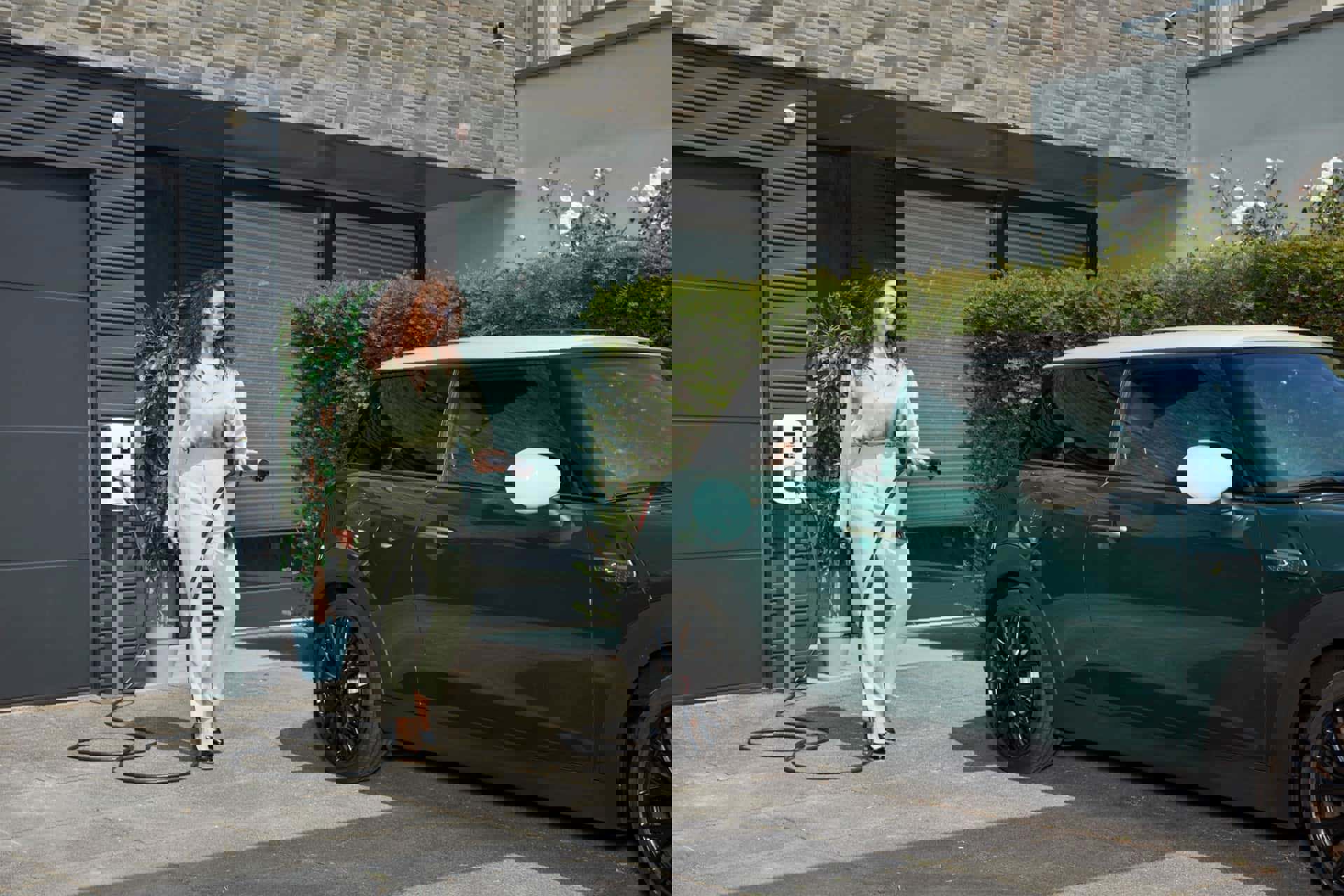 Vrouw stopt laadkabel in elektrische auto