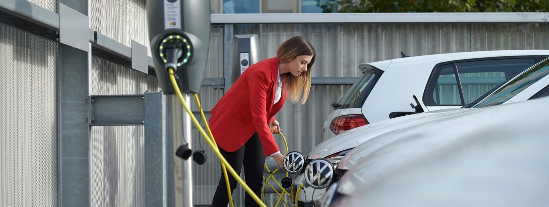 Zakenvrouw laadt auto op bij een van de laadpalen bij kantoor