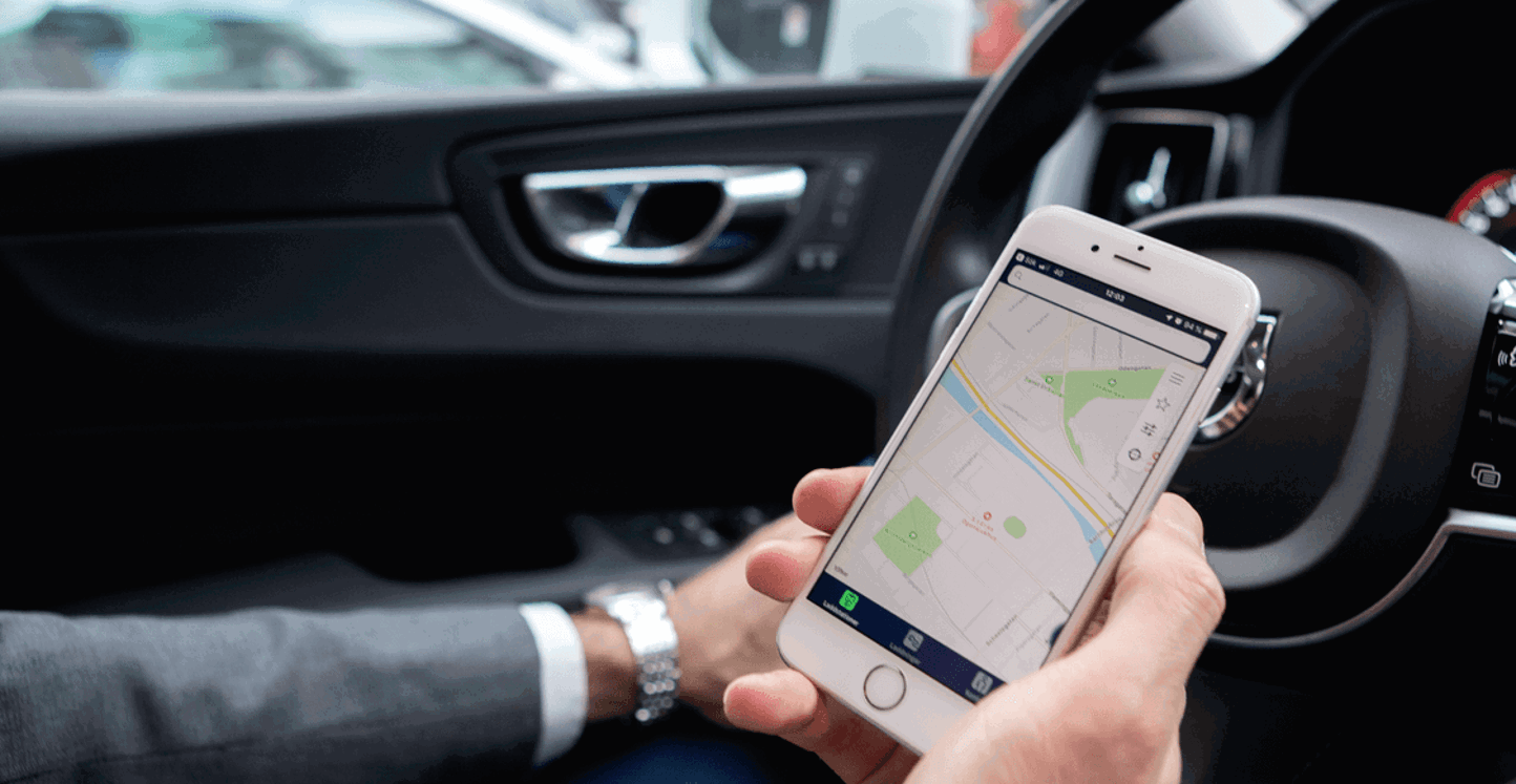 Bestuurder in geparkeerde auto checkt de InCharge app