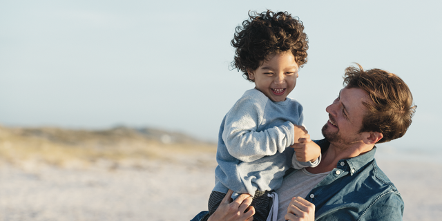 Vader en zoon blij op het strand | Vattenfall over energie