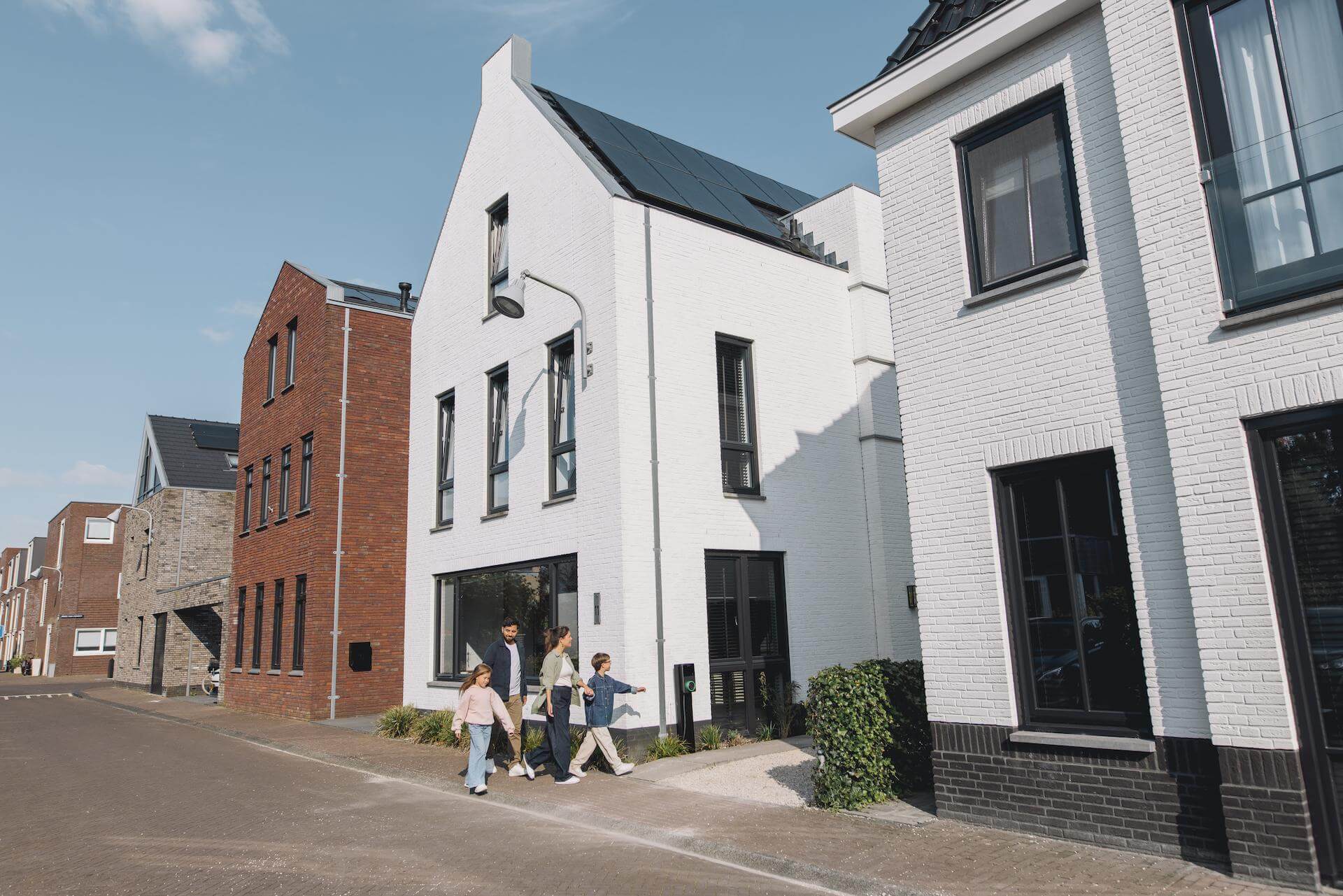Gezin loopt langs huis met zonnepanelen