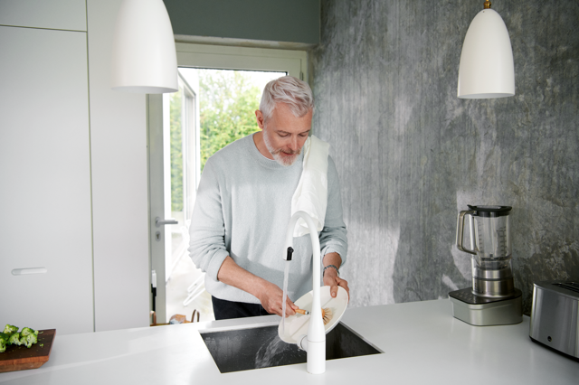 Man wast bord af in de keuken