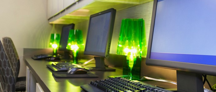Drie laptops met daartussen groene ledlampjes - energieslurpende apparaten uitschakelen