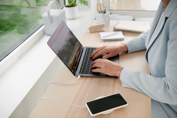 Mevrouw achter bureau met laptop en telefoon