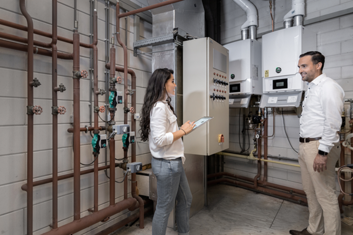 Energie expert praat met een ondernemer in een verwarmingsruimte over tegemoetkomingen in 2023