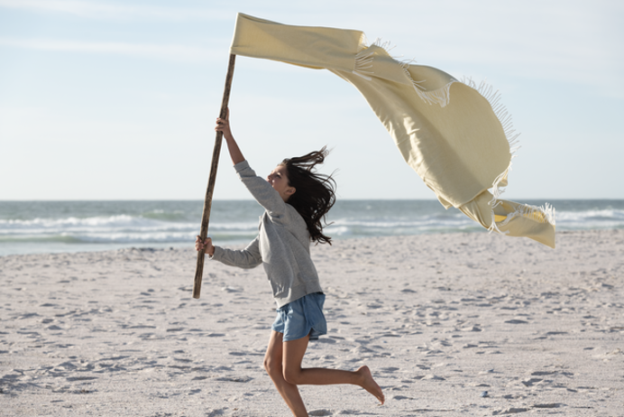 meisje rent op strand met vlag in haar hand