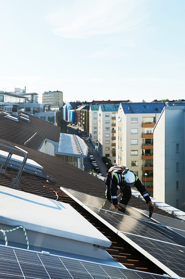 Zonnepanelen monteurs en zonnepanelen op een groot schuin dak in de stad - salderen