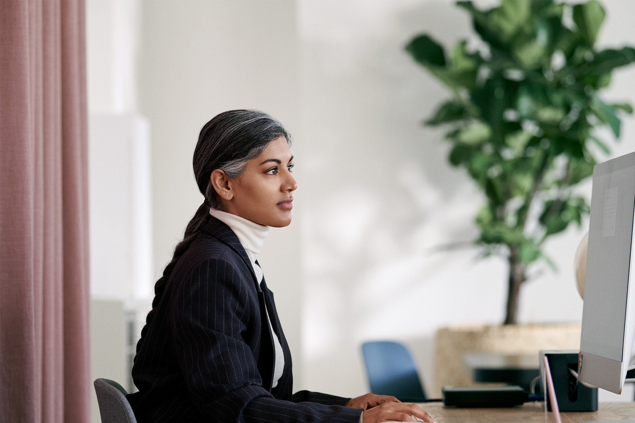 Office manager met zwart haar achter de computer - Je factuur downloaden