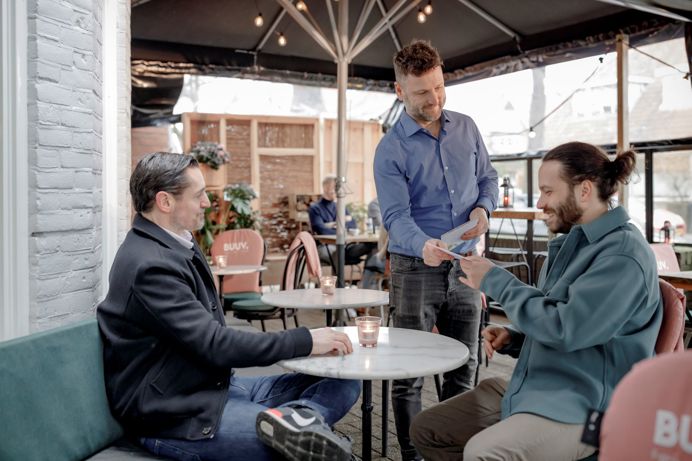 Gasten zitten bij een café op het terras