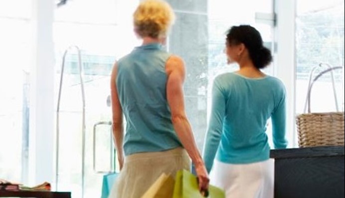 Vrouwen lopen in winkel met energiebesparend luchtgordijn