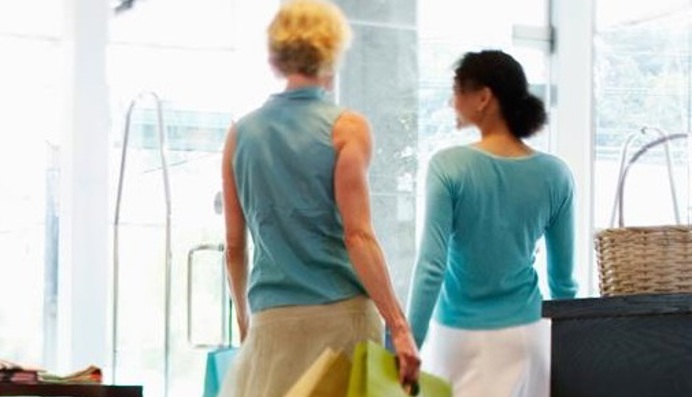 Vrouwen lopen in winkel met energiebesparend luchtgordijn