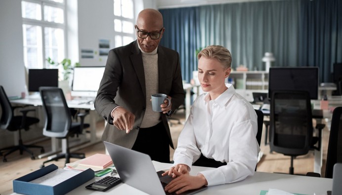 Collega's bespreken mogelijkheden voor betaalhulp achter de laptop