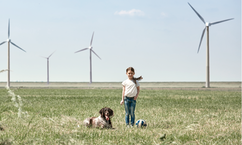 Meisje met hond voor windpark