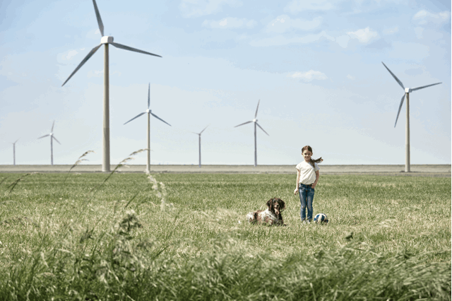 Meisje met hond voor windmolens