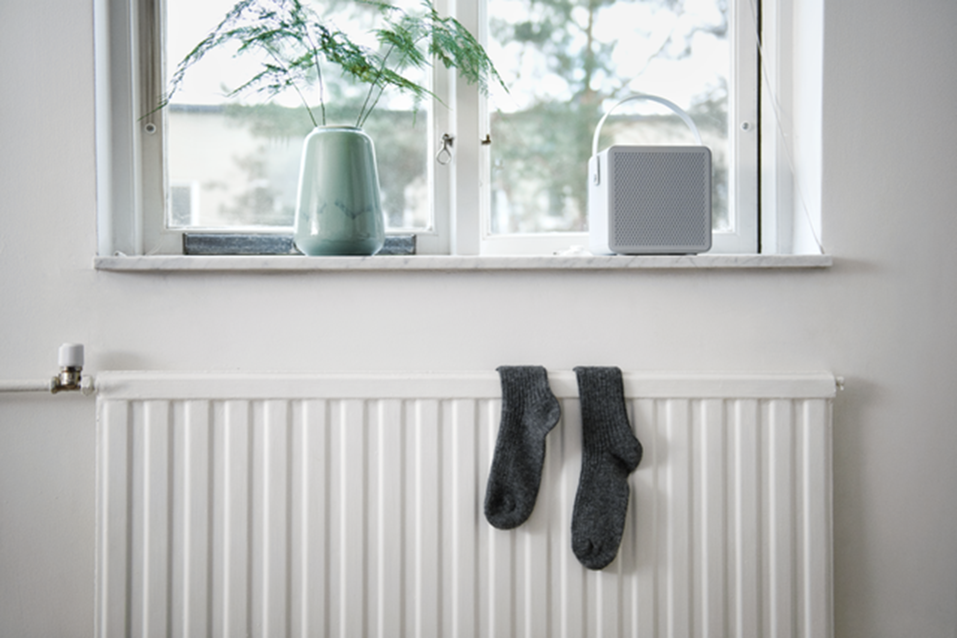 Paar zwarte sokken op een witte radiator