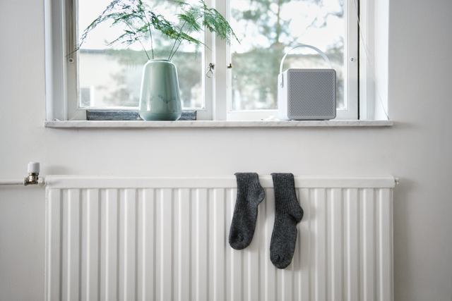 Paar grijze sokken op een witte radiator
