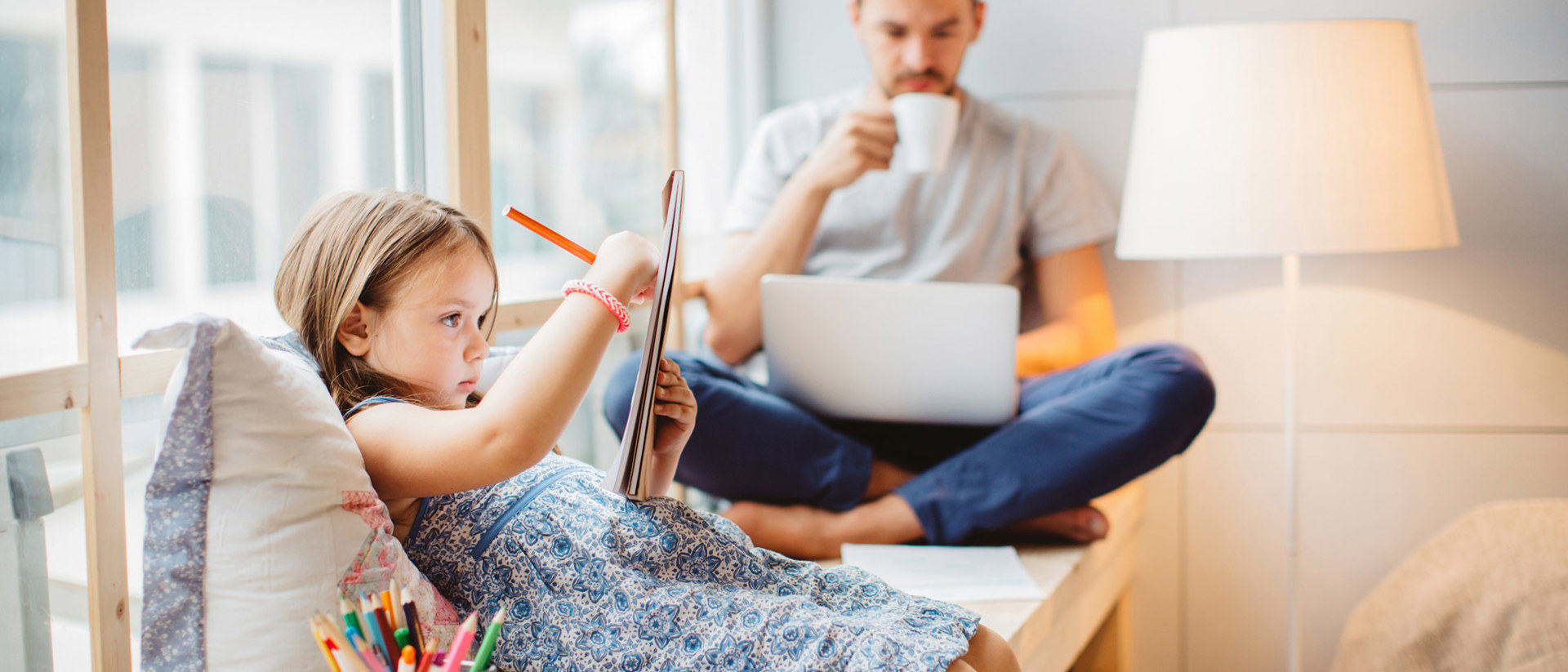 Meisje aan het kleuren vader op de laptop in kozijn | Vattenfall